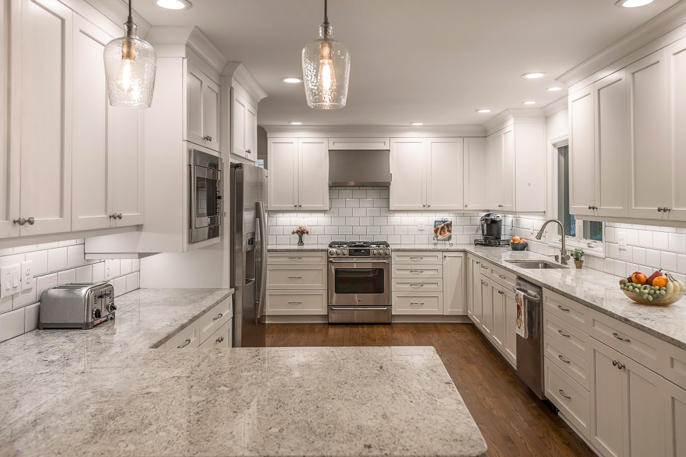 Mid-sized french country l-shaped medium tone wood floor and brown floor eat-in kitchen photo in Atlanta with a drop-in sink, recessed-panel cabinets, white cabinets, granite countertops, white backsplash, subway tile backsplash, stainless steel appliances, a peninsula and yellow countertops