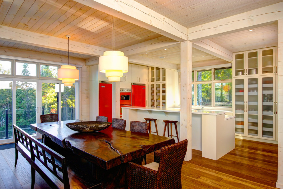 Immagine di una cucina con ante di vetro, ante bianche, elettrodomestici colorati e pavimento in legno massello medio