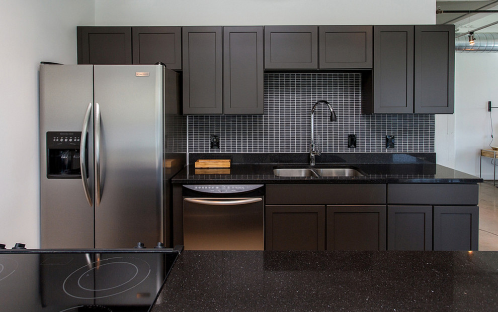 Example of a mid-sized minimalist galley concrete floor and gray floor open concept kitchen design in Other with a double-bowl sink, recessed-panel cabinets, black backsplash, stainless steel appliances, dark wood cabinets, quartz countertops and ceramic backsplash