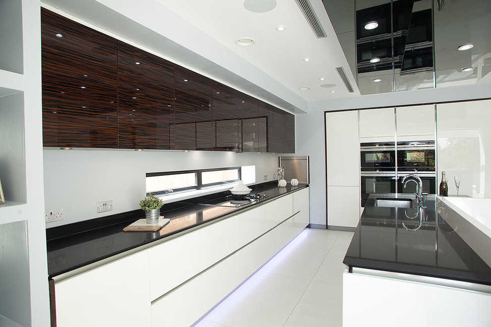 Eat-in kitchen - large contemporary l-shaped porcelain tile eat-in kitchen idea in London with flat-panel cabinets, white cabinets, quartz countertops and an island