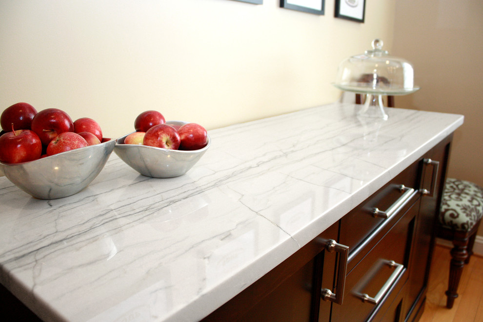 Example of a mid-sized trendy l-shaped light wood floor eat-in kitchen design in Philadelphia with shaker cabinets, dark wood cabinets, a farmhouse sink, white backsplash, stone tile backsplash, stainless steel appliances and an island