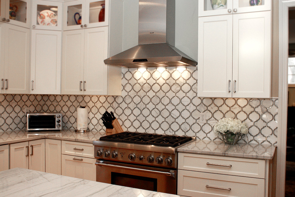 Example of a mid-sized trendy l-shaped light wood floor eat-in kitchen design in Philadelphia with a single-bowl sink, shaker cabinets, white cabinets, quartzite countertops, white backsplash, stone tile backsplash, stainless steel appliances and an island