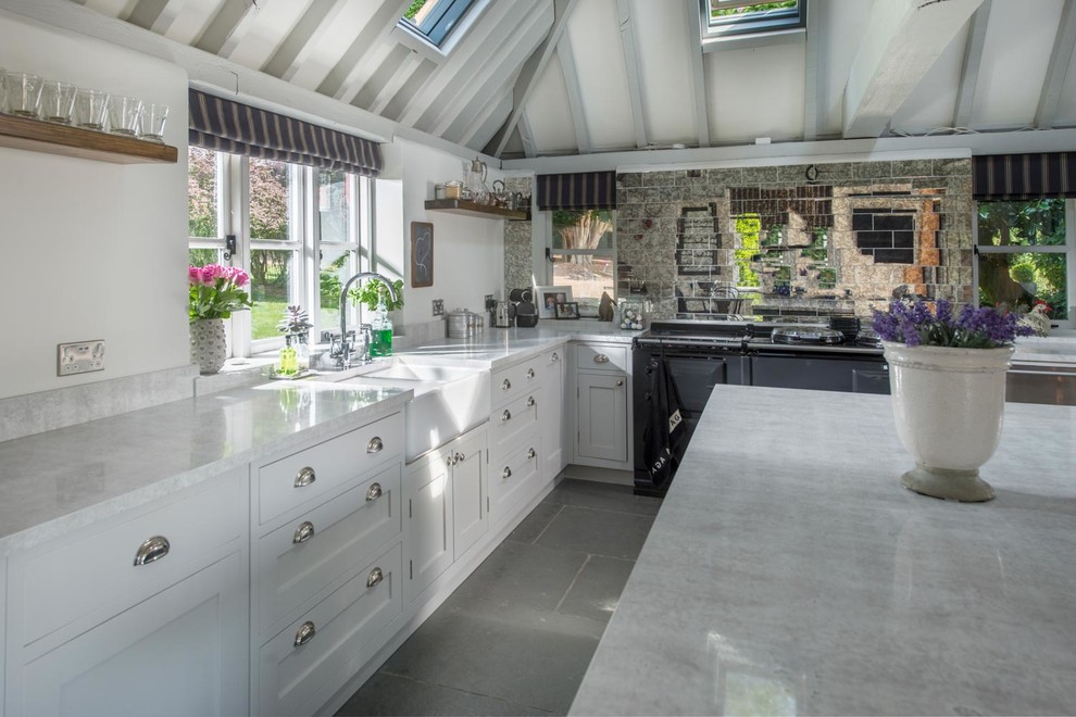 Design ideas for a medium sized farmhouse l-shaped enclosed kitchen in Other with a belfast sink, shaker cabinets, white cabinets, marble worktops, metallic splashback, mirror splashback, slate flooring and an island.