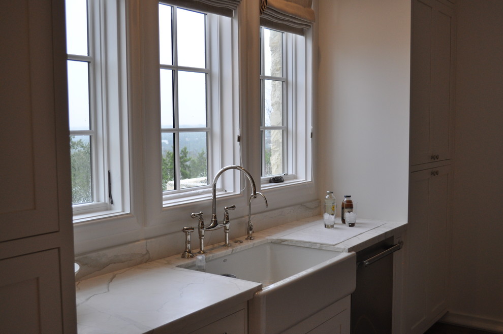 Modern inredning av ett kök och matrum, med en rustik diskho, marmorbänkskiva och vitt stänkskydd