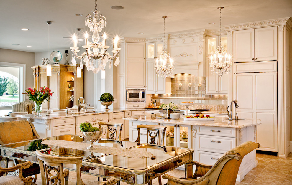 Example of a large classic u-shaped travertine floor eat-in kitchen design in St Louis with a triple-bowl sink, raised-panel cabinets, white cabinets, granite countertops, beige backsplash, stone tile backsplash, paneled appliances and an island