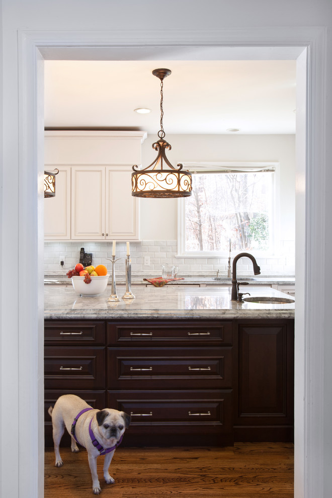 Bild på ett stort vintage kök, med luckor med upphöjd panel, vita skåp, marmorbänkskiva, vitt stänkskydd, stänkskydd i stenkakel, rostfria vitvaror, mörkt trägolv och en köksö