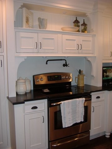 Esempio di una cucina classica con lavello stile country, ante con riquadro incassato, ante bianche, top in granito, elettrodomestici in acciaio inossidabile e parquet scuro