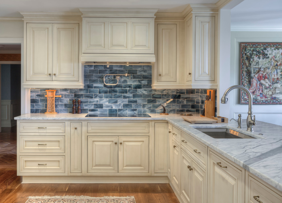 Foto de cocina clásica con fregadero bajoencimera, armarios con rebordes decorativos, puertas de armario beige y salpicadero azul