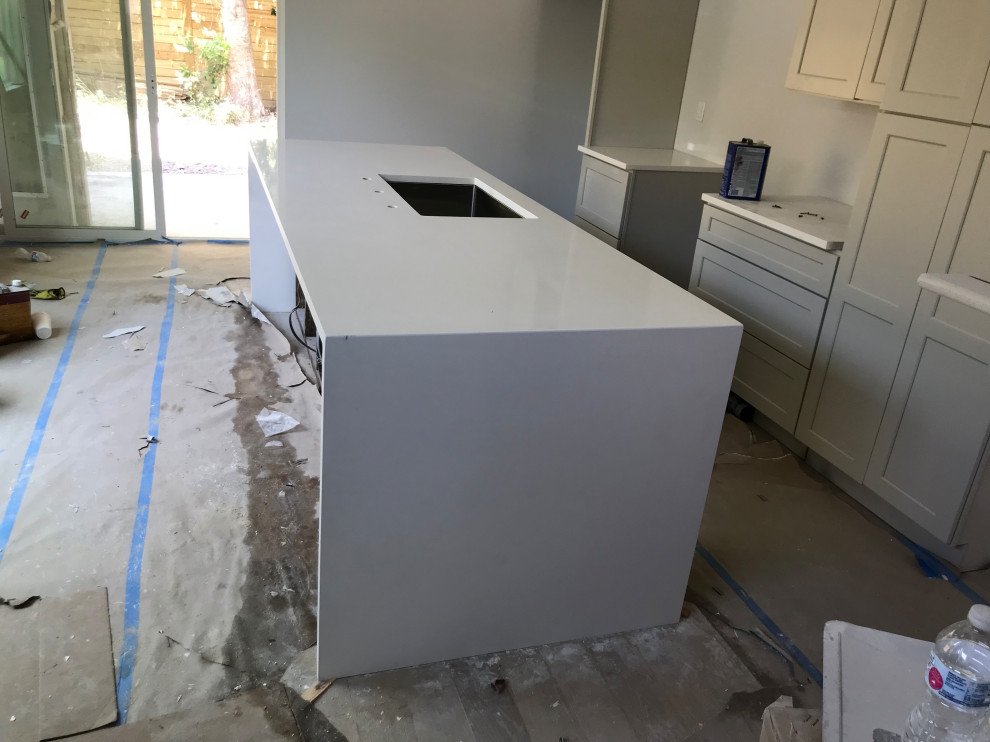 White quartz waterfall island for new construction Modern Kitchen