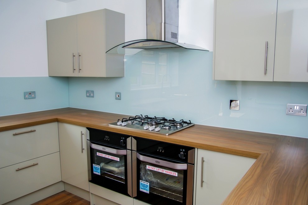 Photo of a modern kitchen in Hertfordshire with glass sheet splashback.