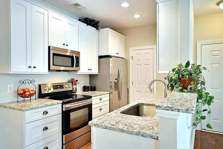 Inspiration för ett litet funkis kök, med en enkel diskho, skåp i shakerstil, vita skåp, träbänkskiva, rostfria vitvaror, plywoodgolv, en halv köksö och brunt golv