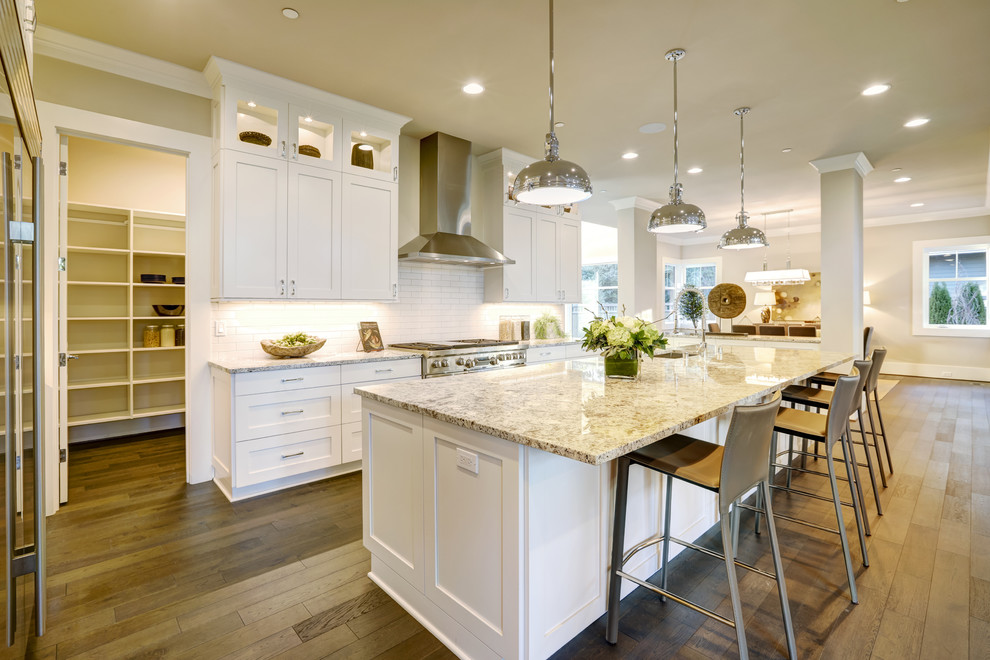 Mid-sized minimalist galley dark wood floor and brown floor eat-in kitchen photo in DC Metro with a single-bowl sink, flat-panel cabinets, white cabinets, granite countertops, white backsplash, ceramic backsplash, stainless steel appliances, an island and beige countertops