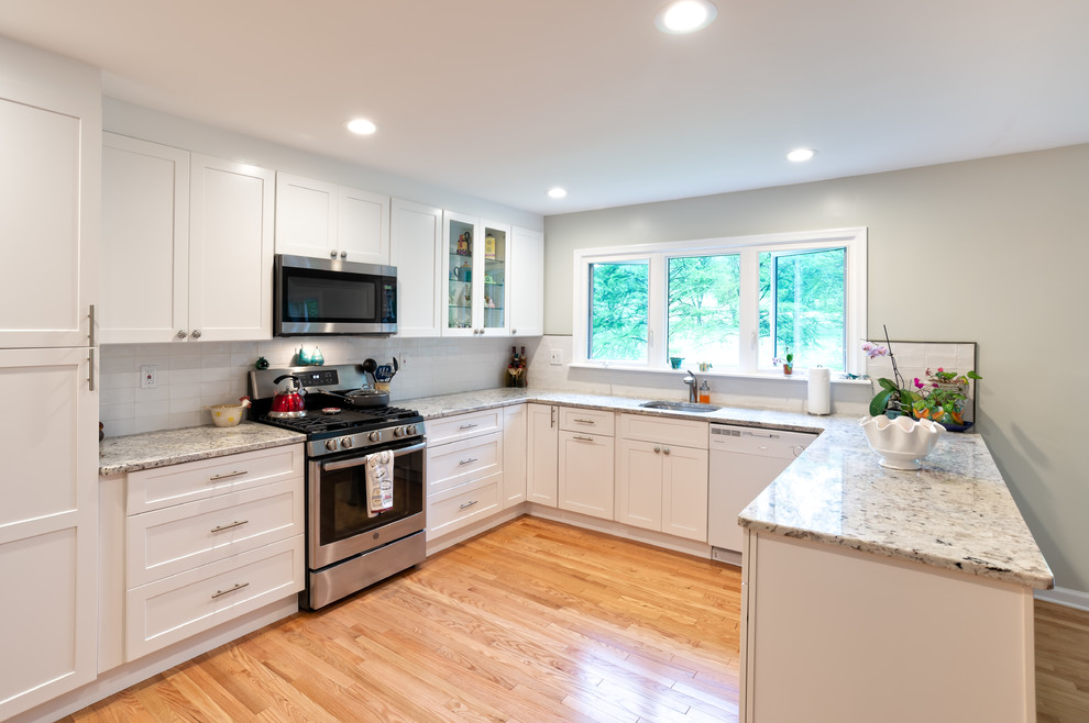 Example of a mid-sized transitional u-shaped light wood floor and brown floor eat-in kitchen design in Philadelphia with an undermount sink, shaker cabinets, white cabinets, quartz countertops, white backsplash, subway tile backsplash, stainless steel appliances, no island and yellow countertops