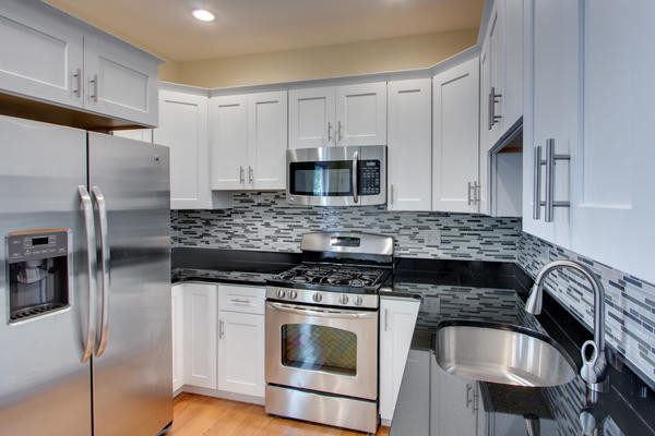 Example of a mid-sized trendy kitchen design in Boston with a drop-in sink, recessed-panel cabinets, white cabinets, multicolored backsplash and stainless steel appliances