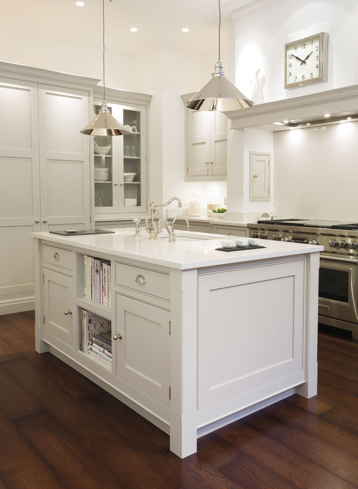 Bild på ett stort funkis kök, med skåp i shakerstil, vita skåp, vitt stänkskydd, rostfria vitvaror, mörkt trägolv, en köksö och brunt golv