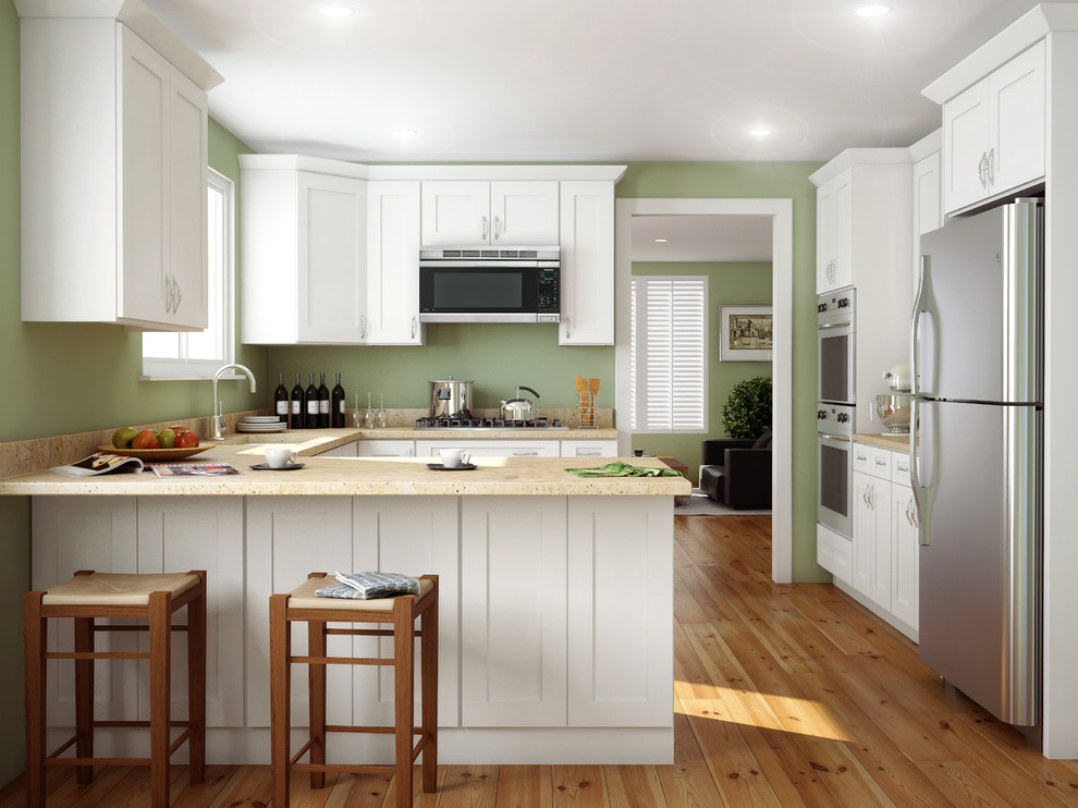 Idéer för att renovera ett mellanstort amerikanskt u-kök, med skåp i shakerstil, vita skåp, rostfria vitvaror, ljust trägolv, en halv köksö, en undermonterad diskho, bänkskiva i kvarts och beiget golv