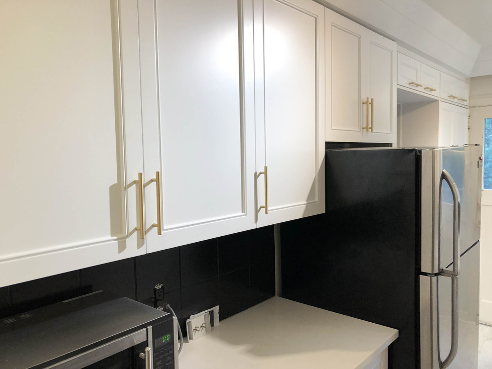 Enclosed kitchen - small modern galley laminate floor and beige floor enclosed kitchen idea in Toronto with an undermount sink, shaker cabinets, white cabinets, quartz countertops, gray backsplash, ceramic backsplash, stainless steel appliances, no island and white countertops