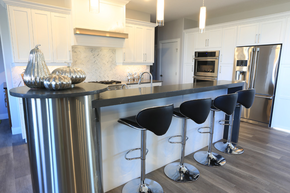 Zweizeilige, Mittelgroße Klassische Wohnküche mit Schrankfronten im Shaker-Stil, weißen Schränken, Küchengeräten aus Edelstahl, Kücheninsel, Quarzit-Arbeitsplatte, Küchenrückwand in Weiß, Rückwand aus Glasfliesen und Porzellan-Bodenfliesen in Edmonton