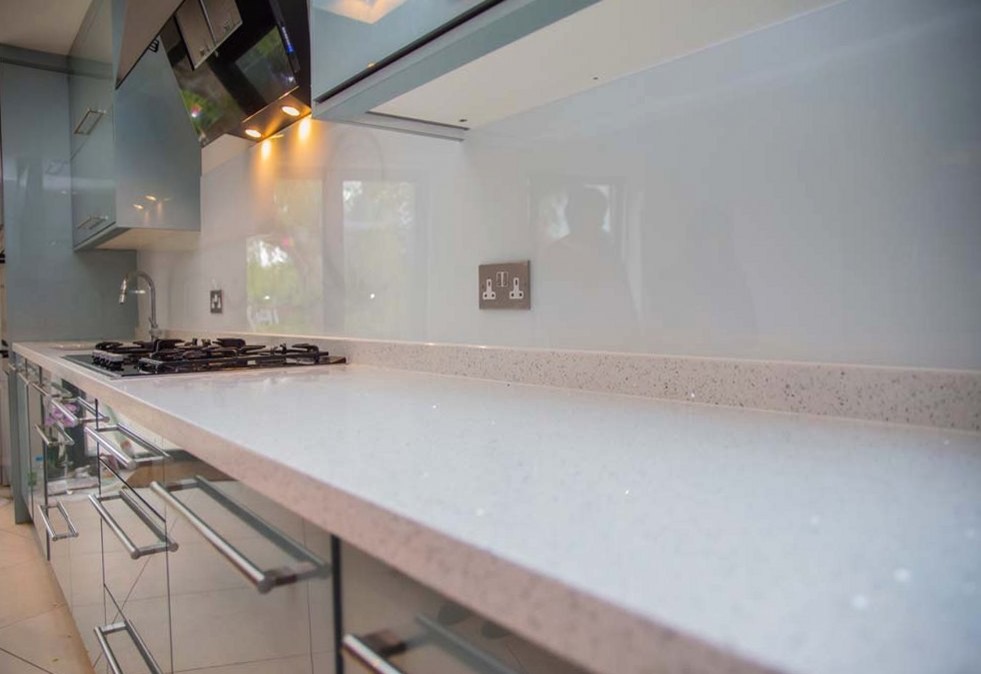 Cette photo montre une cuisine moderne avec une crédence blanche et une crédence en feuille de verre.