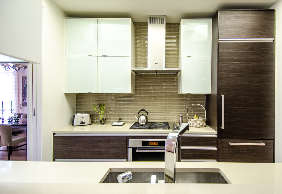 Design ideas for a medium sized modern galley kitchen in New York with a submerged sink, flat-panel cabinets, dark wood cabinets, engineered stone countertops, green splashback, glass tiled splashback, integrated appliances and light hardwood flooring.