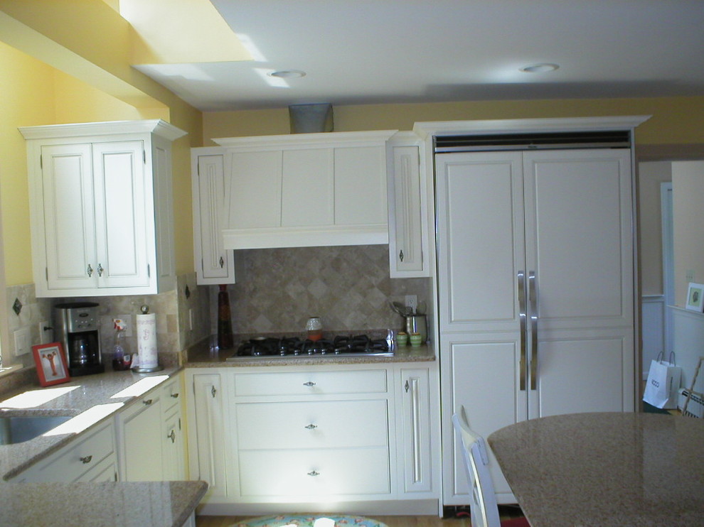 Klassisk inredning av ett mellanstort kök och matrum, med luckor med profilerade fronter, vita skåp och granitbänkskiva