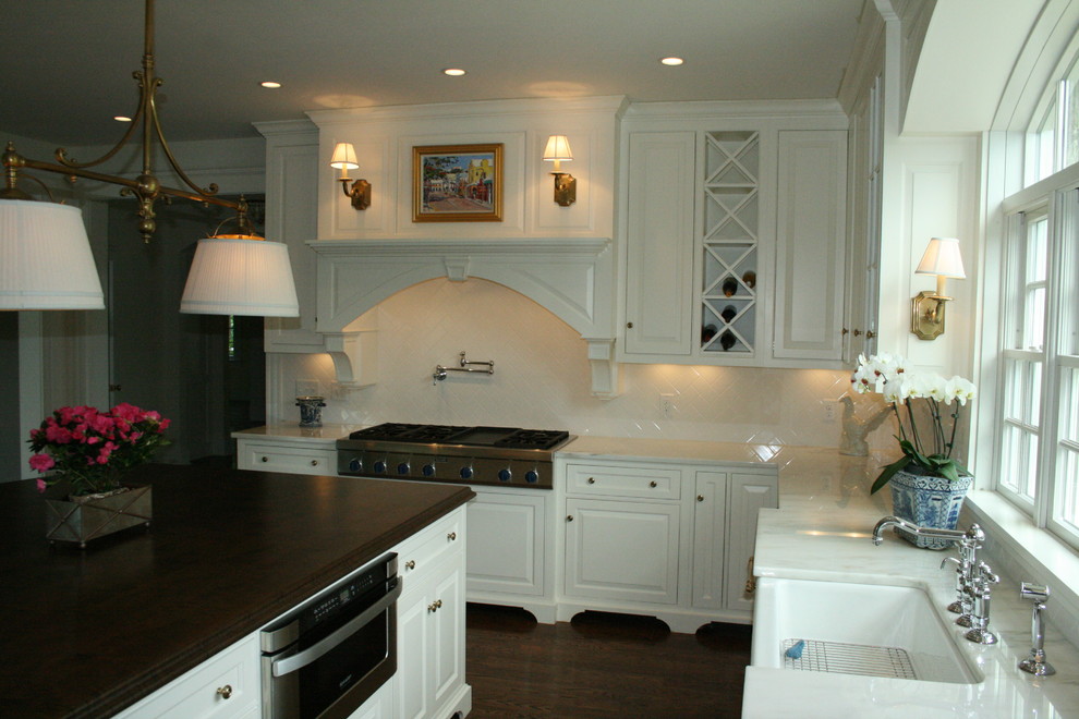 Example of a classic u-shaped eat-in kitchen design in Cincinnati with a farmhouse sink, beaded inset cabinets, white cabinets, marble countertops, white backsplash, subway tile backsplash and paneled appliances