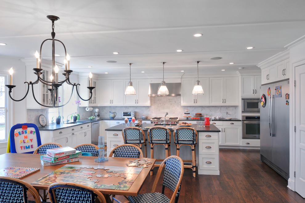 Inspiration for a large timeless l-shaped dark wood floor eat-in kitchen remodel in New York with white cabinets, granite countertops, white backsplash, stainless steel appliances, a single-bowl sink, shaker cabinets, stone slab backsplash and an island