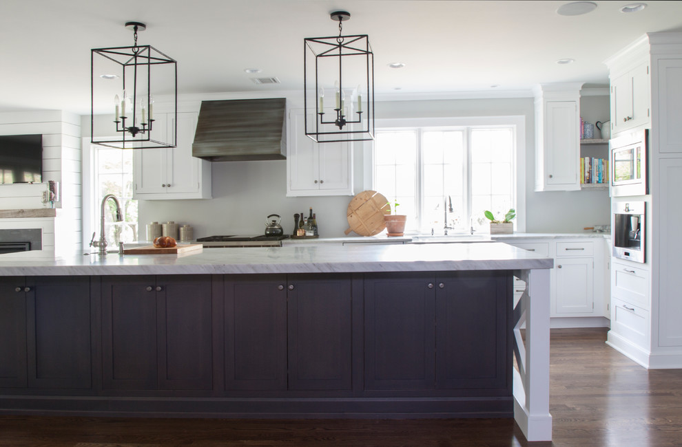 Large transitional l-shaped dark wood floor enclosed kitchen photo in Newark with an island, shaker cabinets, white cabinets, marble countertops, white backsplash, a farmhouse sink and stainless steel appliances