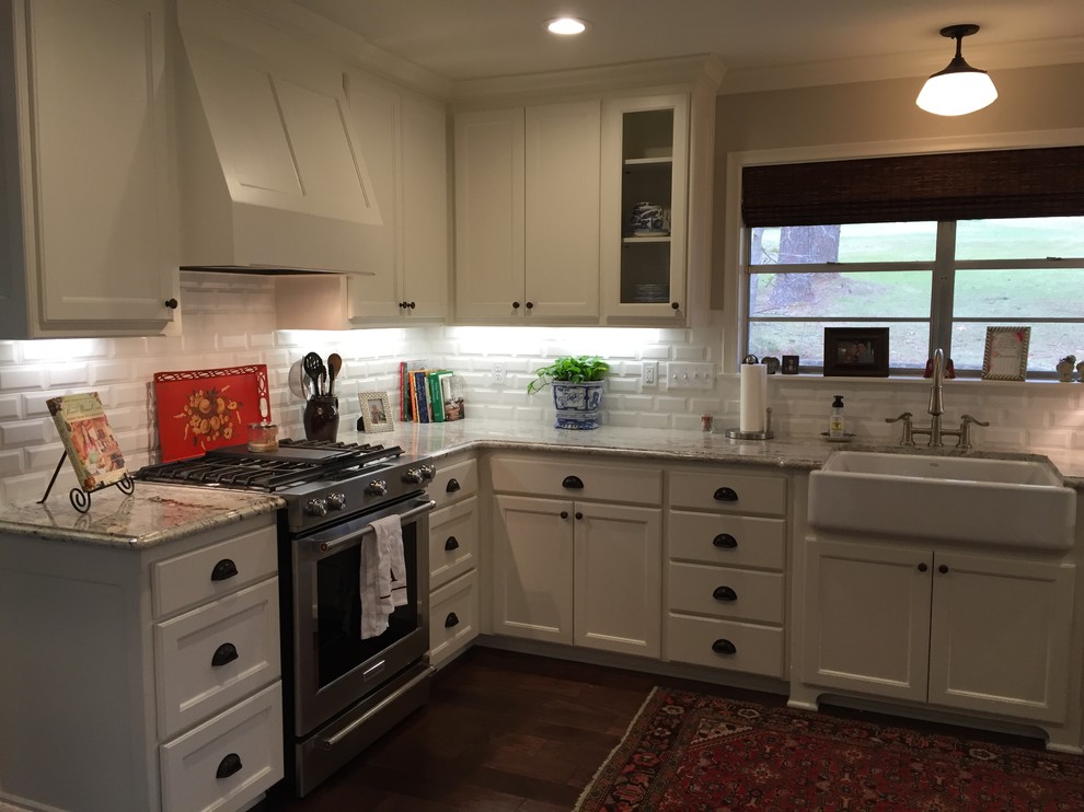 This is an example of a large traditional u-shaped open plan kitchen in Houston with a belfast sink, shaker cabinets, white cabinets, marble worktops, white splashback, stainless steel appliances, dark hardwood flooring and a breakfast bar.