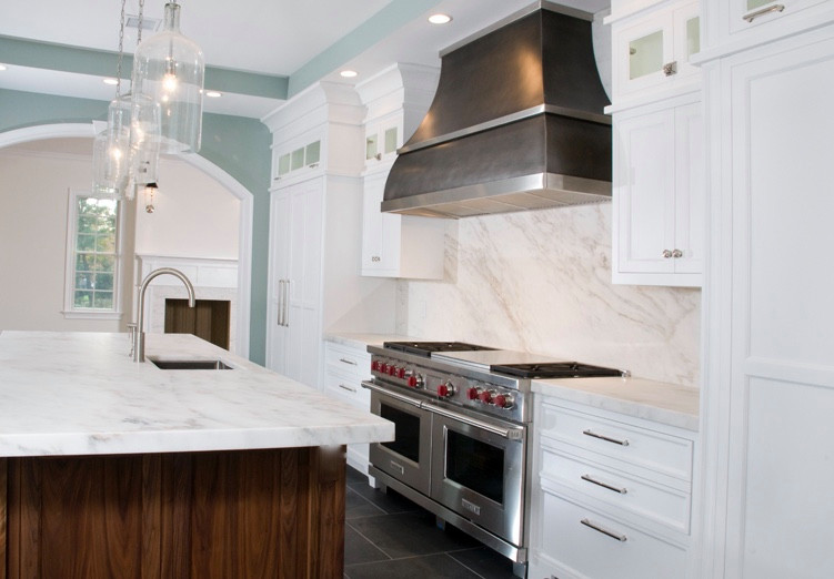 Exempel på ett stort klassiskt vit vitt kök, med en undermonterad diskho, luckor med infälld panel, vita skåp, marmorbänkskiva, vitt stänkskydd, stänkskydd i marmor, integrerade vitvaror, marmorgolv, en köksö och svart golv