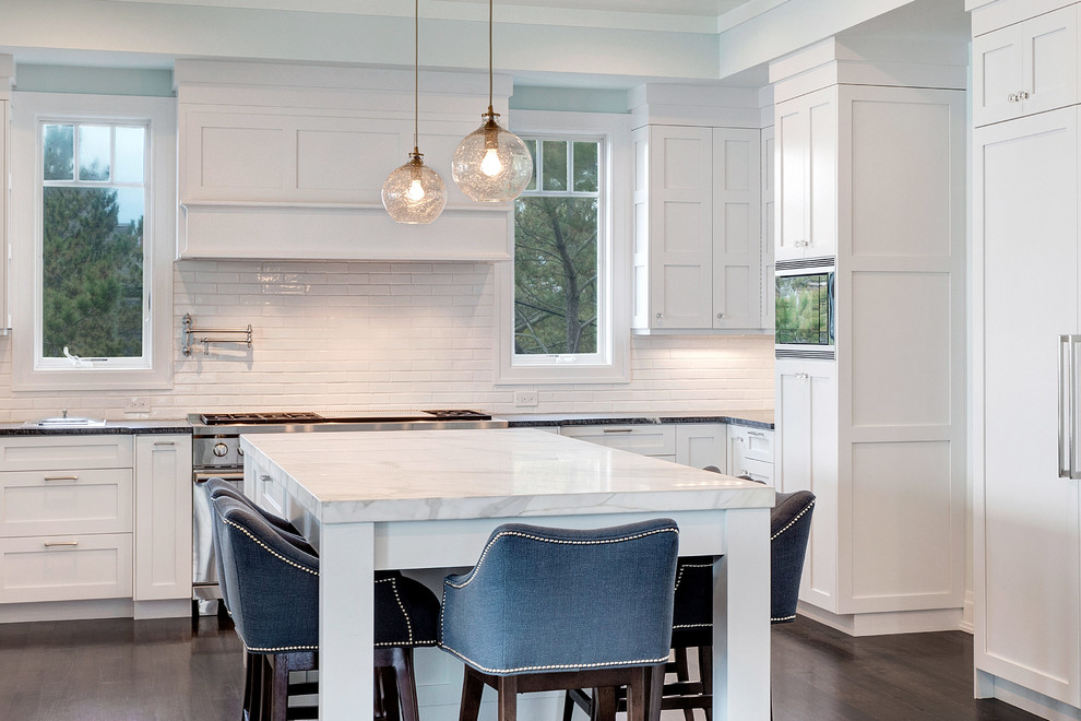 Eat-in kitchen - large transitional u-shaped dark wood floor eat-in kitchen idea in New York with an undermount sink, shaker cabinets, white cabinets, soapstone countertops, white backsplash, subway tile backsplash, paneled appliances and an island