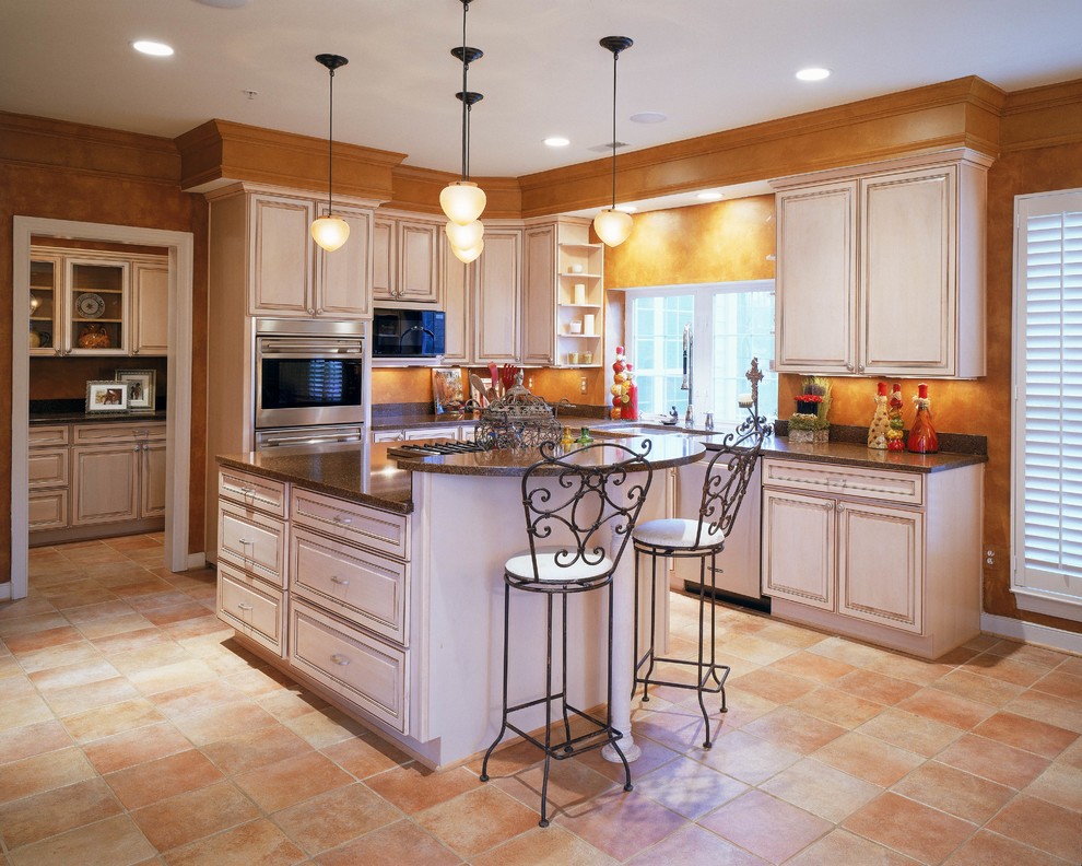 Foto di una grande cucina classica con lavello da incasso, ante lisce, ante bianche, top in granito, paraspruzzi arancione e elettrodomestici in acciaio inossidabile