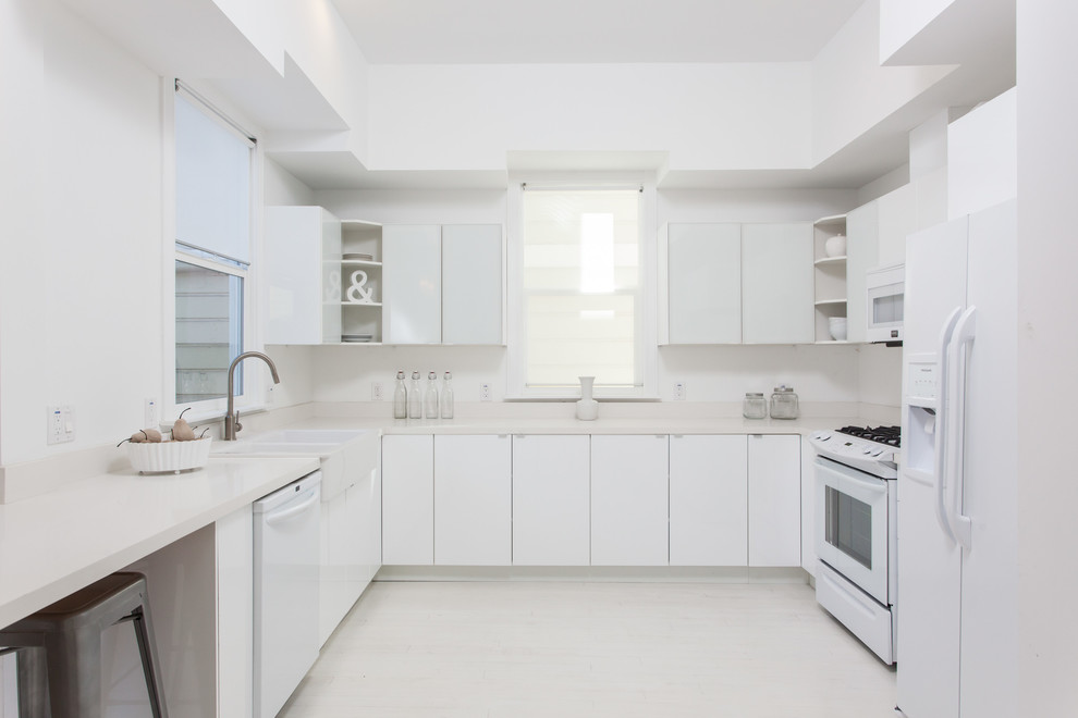 Inspiration for a modern kitchen in San Francisco with flat-panel cabinets, white appliances, a built-in sink and white cabinets.