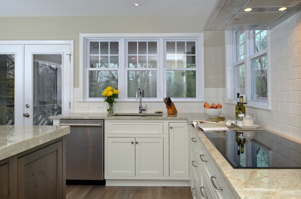 Exempel på ett mellanstort klassiskt kök, med en undermonterad diskho, släta luckor, vita skåp, vitt stänkskydd, stänkskydd i porslinskakel, rostfria vitvaror, mellanmörkt trägolv och en köksö