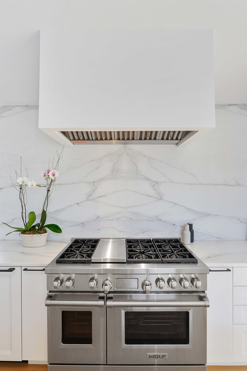 All White Kitchen with Flat-panel Cabinets and Bookmatched Tile Backsplash