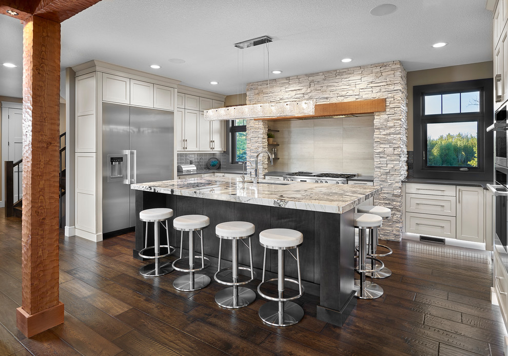 Example of a mid-sized mountain style u-shaped dark wood floor eat-in kitchen design in Vancouver with an undermount sink, shaker cabinets, granite countertops, beige backsplash, stainless steel appliances and an island
