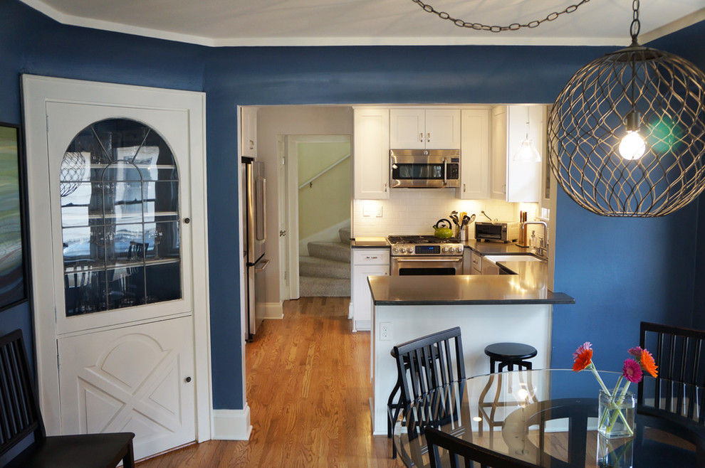 Foto de cocina contemporánea con fregadero sobremueble, puertas de armario blancas, encimera de acrílico, salpicadero blanco, salpicadero de azulejos tipo metro y electrodomésticos de acero inoxidable