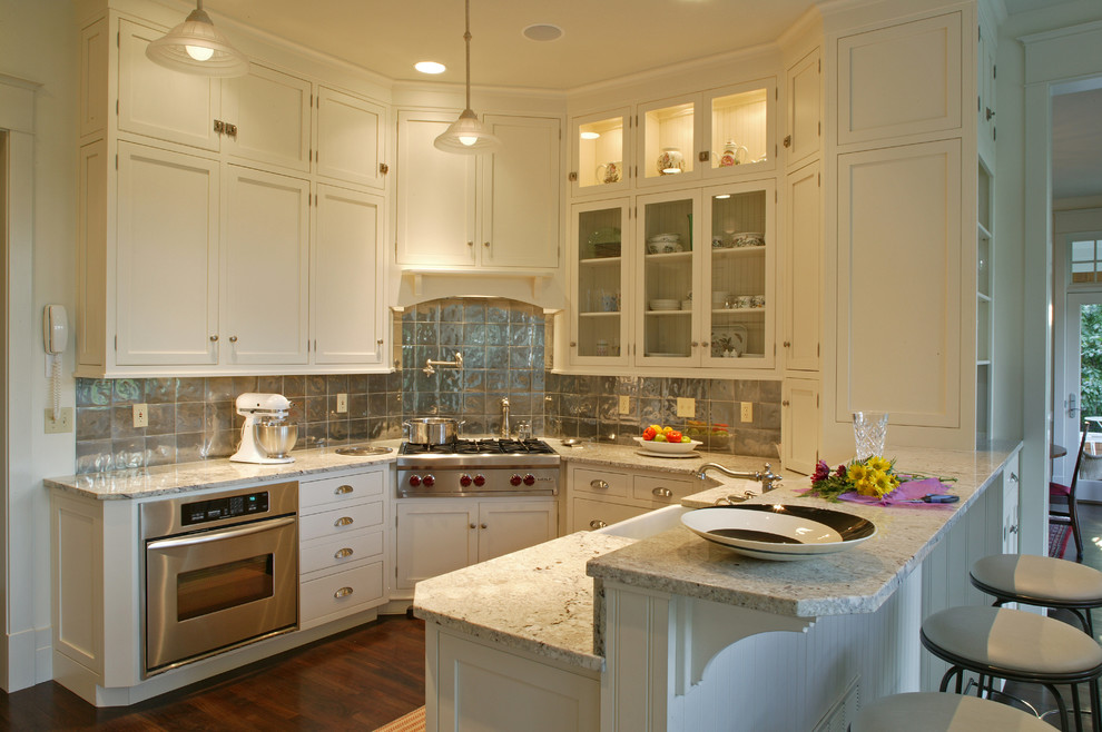 Klassische Küche in U-Form mit Glasfronten, Granit-Arbeitsplatte, Küchengeräten aus Edelstahl, Küchenrückwand in Metallic und Rückwand aus Metallfliesen in Baltimore