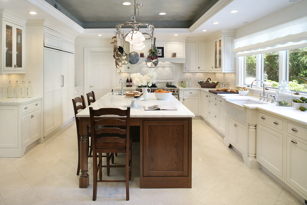 Idéer för vintage u-kök, med en rustik diskho, luckor med infälld panel, vita skåp, marmorbänkskiva och vitt stänkskydd