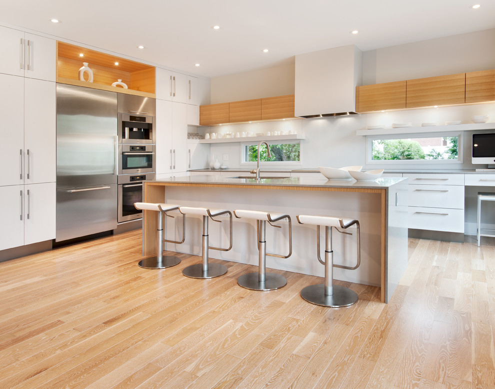 Moderne Küche in L-Form mit flächenbündigen Schrankfronten, weißen Schränken und Küchengeräten aus Edelstahl in Ottawa