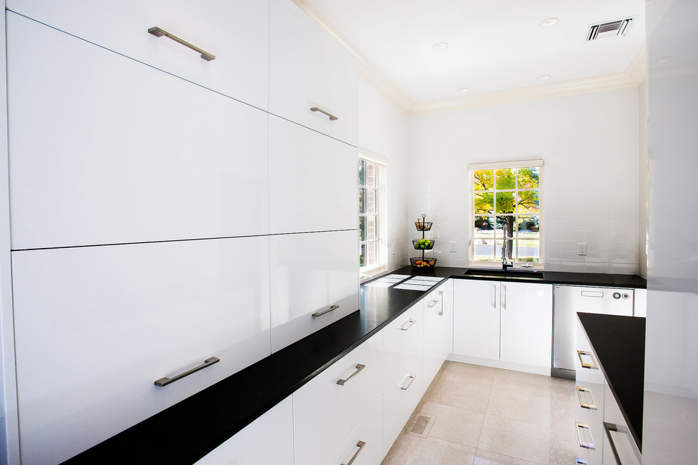 Ejemplo de cocina minimalista de tamaño medio con armarios con paneles lisos, puertas de armario blancas y península