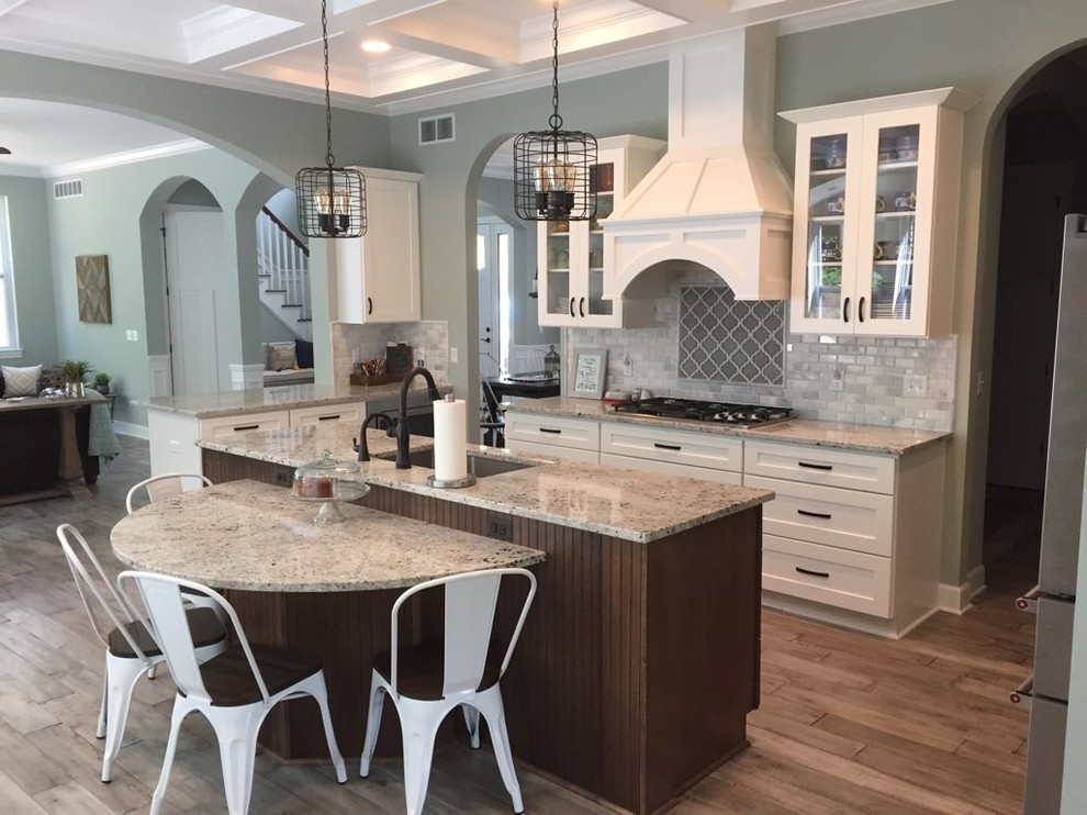 Inspiration for a mid-sized transitional galley plywood floor and gray floor eat-in kitchen remodel in Detroit with a single-bowl sink, recessed-panel cabinets, white cabinets, granite countertops, multicolored backsplash, ceramic backsplash, stainless steel appliances and an island