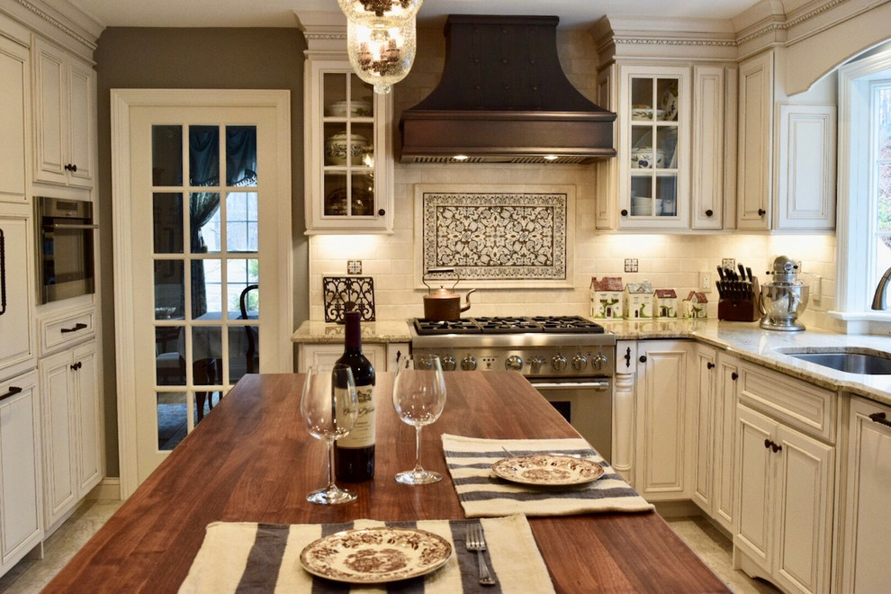 Inspiration for a mid-sized timeless u-shaped enclosed kitchen remodel in Philadelphia with an undermount sink, raised-panel cabinets, beige cabinets, granite countertops, beige backsplash, subway tile backsplash, an island and beige countertops