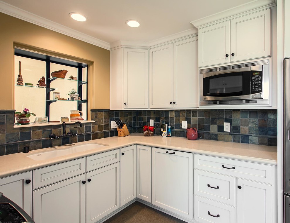 This is an example of a small traditional u-shaped kitchen in Los Angeles with a double-bowl sink, recessed-panel cabinets, white cabinets, engineered stone countertops, terracotta splashback, stainless steel appliances and lino flooring.