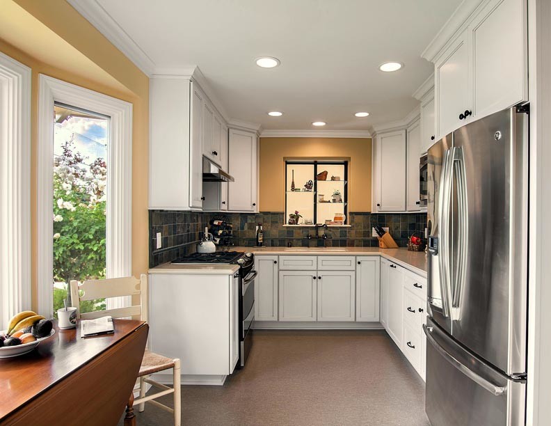 Small transitional u-shaped linoleum floor kitchen photo in Los Angeles with a double-bowl sink, recessed-panel cabinets, white cabinets, quartz countertops, terra-cotta backsplash and stainless steel appliances