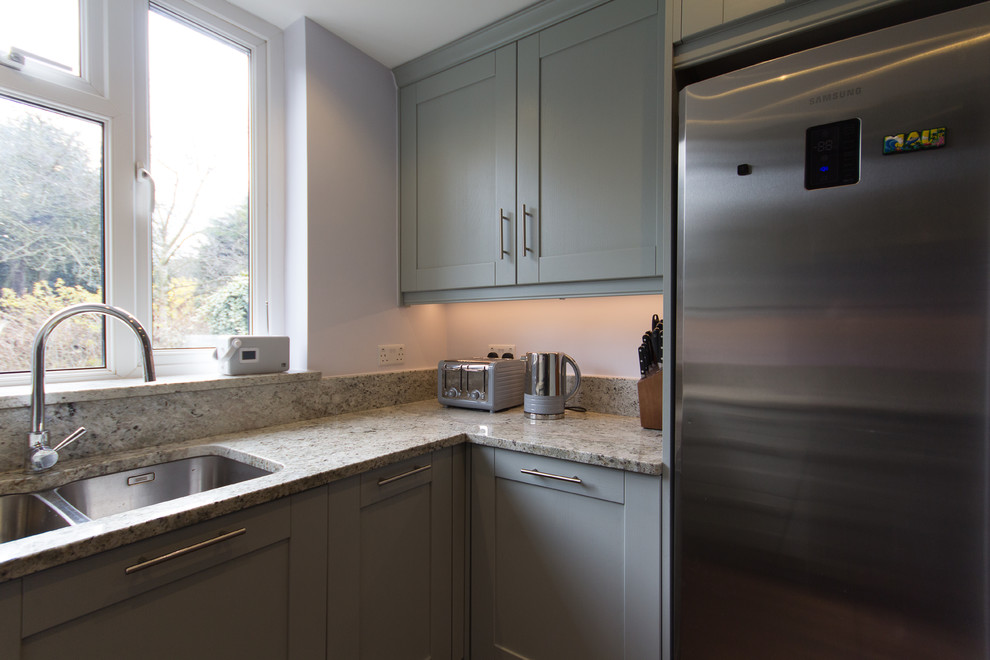 Inspiration for a medium sized modern u-shaped enclosed kitchen in London with an integrated sink, shaker cabinets, grey cabinets, granite worktops, pink splashback, glass sheet splashback, stainless steel appliances, porcelain flooring and no island.