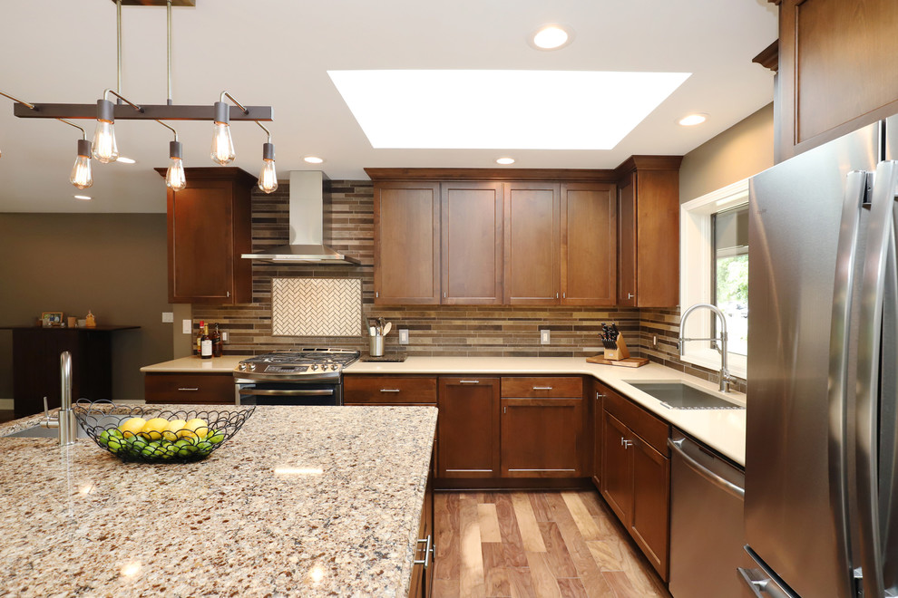 Exempel på ett stort klassiskt kök, med en dubbel diskho, skåp i shakerstil, skåp i mellenmörkt trä, granitbänkskiva, brunt stänkskydd, stänkskydd i keramik, rostfria vitvaror, mellanmörkt trägolv, en köksö och brunt golv