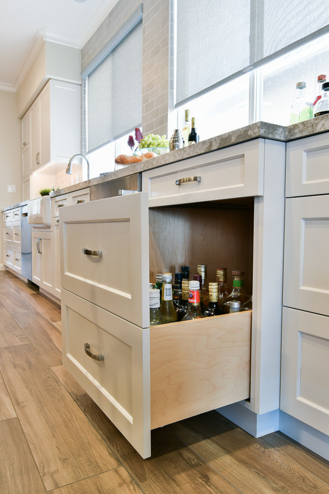 Modelo de cocinas en U costero, de tamaño medio, abierto, con fregadero sobremueble, armarios estilo shaker, puertas de armario blancas, encimera de cuarzo compacto, salpicadero verde, salpicadero de azulejos de cerámica, electrodomésticos de acero inoxidable, suelo de baldosas de cerámica y una isla