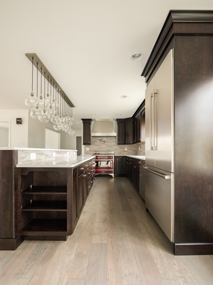 Inspiration for a mid-sized modern galley dark wood floor and brown floor open concept kitchen remodel in New York with a single-bowl sink, shaker cabinets, dark wood cabinets, quartz countertops, gray backsplash, ceramic backsplash, stainless steel appliances, an island and gray countertops