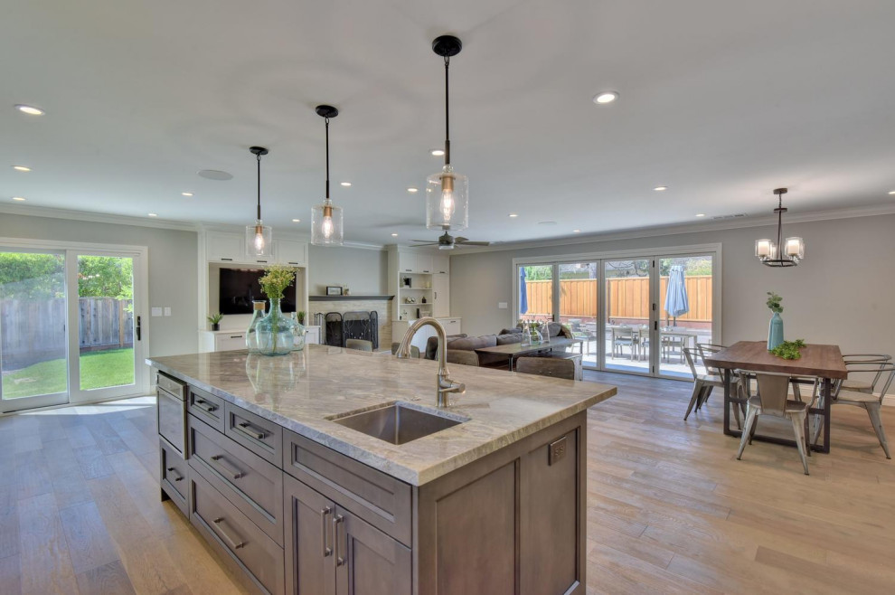 Exempel på ett mellanstort modernt flerfärgad flerfärgat kök, med en undermonterad diskho, skåp i shakerstil, vita skåp, bänkskiva i kvartsit, grått stänkskydd, stänkskydd i glaskakel, rostfria vitvaror, laminatgolv, en köksö och brunt golv